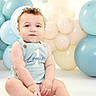 baby, balloons, birthday, blue_clothing, celebration, child, cute, decorations, event, happy, indoor, infant, one_year_old, pastel_colors, person, portrait, sitting, smiling, studio, young_child