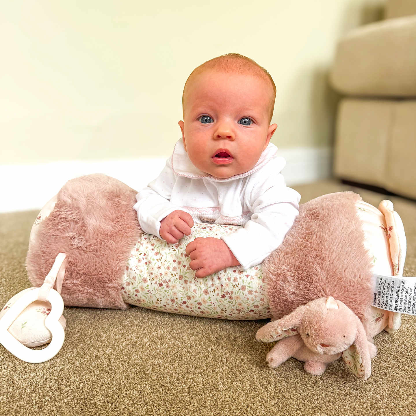 Larna joined the competition — help win amazing prizes! baby, blue_eyes, blurred_background, carpet, child, couch, cozy, curious_expression, cute, face, floor, hands, home, indoor, infant, plush_pillow, portrait, soft_toy, toddler, white_clothing