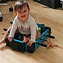élyne participe au concours pour gagner de l'argent avec cette photo : toddler, child, smile, indoor, foosball_table, toy, floor, wood_floor, clothing, person, play, happy, furniture, plastic_toy, room, hair, foot, sitting, hand, face