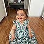 barefoot, bench, child, clothing, cushion, cute, dress, face, floral_pattern, hairclip, happy, home, indoor, person, room, sitting, smile, toddler, wooden_floor, young_child
