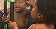 Azari joined the competition — help win amazing prizes! toddler, child, mirror, baseball_bats, reflection, curly_hair, shirtless, blue_shorts, indoor, window, blinds, wall_decor, butterfly, hand, high_five, playful, person, young_child, home, room