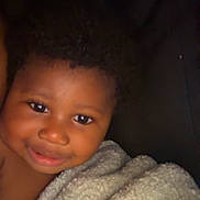 Azari joined the competition — help win amazing prizes! toddler, child, smiling, blanket, face, curly_hair, portrait, happy, closeup, skin, baby, comfort, warmth, expression, indoors, soft_texture, cozy, person, head, cuddle