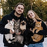 Kitty Baby is registered to the contest to win money with this photo: person, man, woman, cat, outdoor, snow, forest, tree, animal, pet, holding, happy, smile, casual_clothing, nature, sunlight, daylight, portrait, group, cute