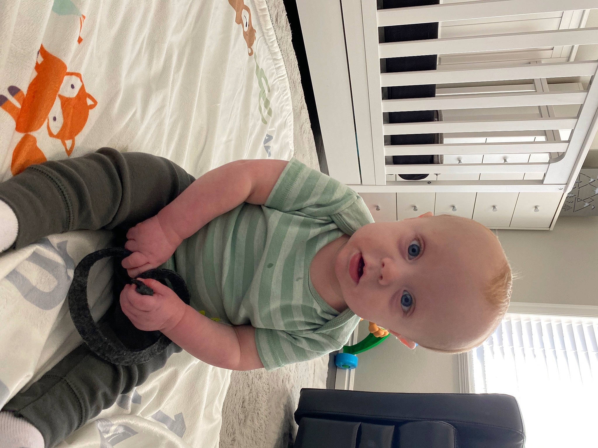 Ledger is registered to the contest to win money with this photo: baby, baby_products, baby_safety, baby_toddler_clothing, child, comfort, eye, finger, happy, person, room, sitting, smile, surprise, t_shirt, toddler, wood