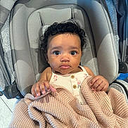 Alevyn joined the competition — help win amazing prizes! baby, infant, blanket, knitted_blanket, baby_seat, curly_hair, clothing, indoors, child, person, cute, looking_up, soft_texture, comfortable, seat, hands, expression, portrait, skin, young