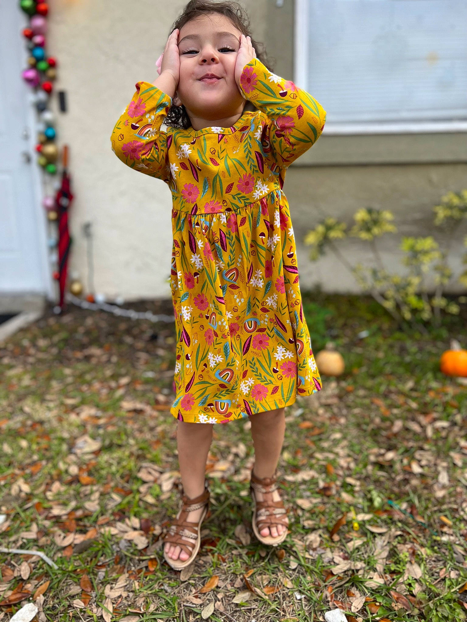 Olivia is registered to the contest to win money with this photo: baby_toddler_clothing, child, day_dress, dress, foot, fun, grass, happy, head, human_leg, magenta, one_piece_garment, pattern, people_in_nature, person, plant, play, sandal, sleeve, standing
