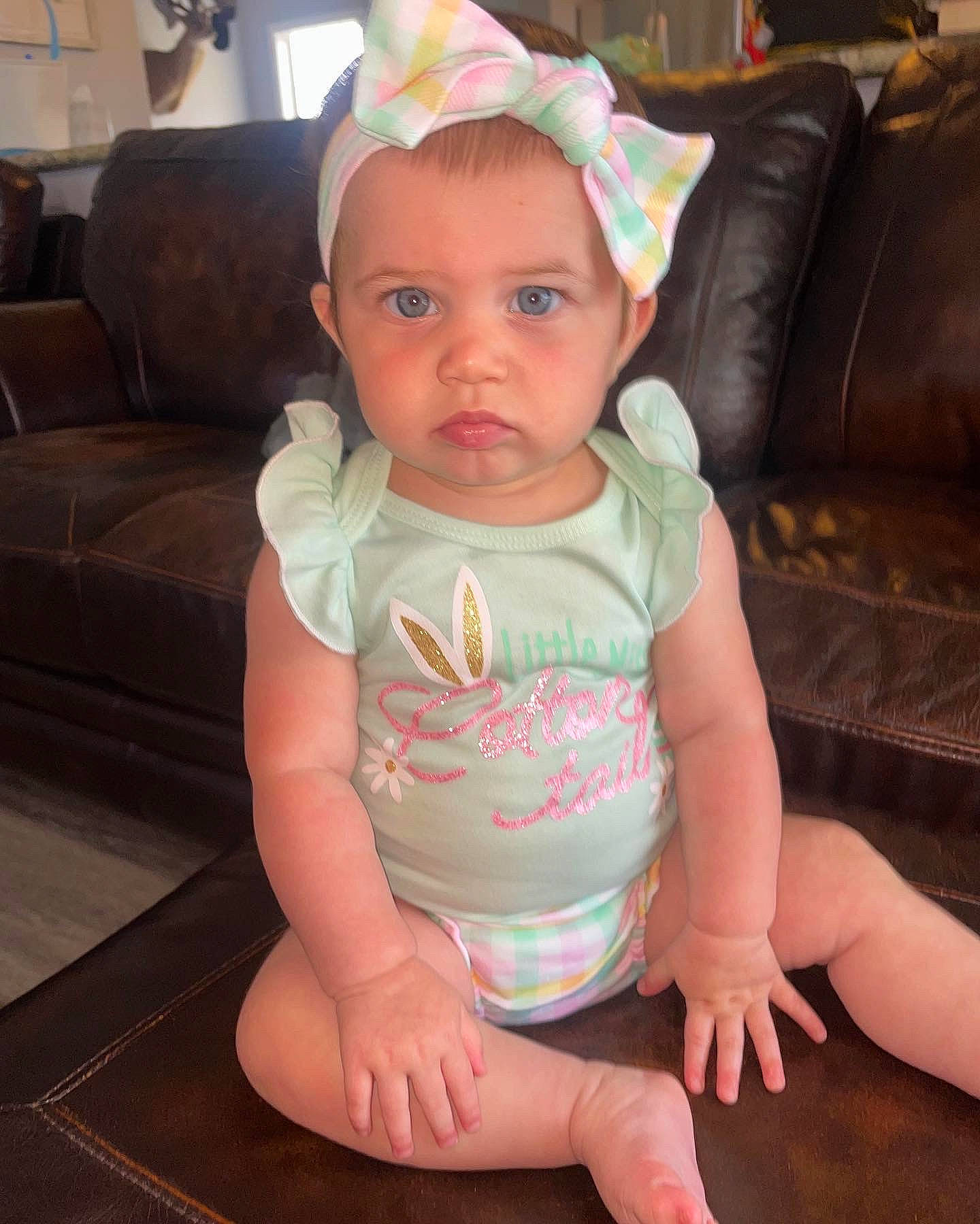 Lilah is registered to the contest to win money with this photo: arm, baby, baby_toddler_clothing, cheek, chin, comfort, couch, eye, face, finger, flooring, head, iris, lap, neck, person, pink, skin, sleeve, thigh