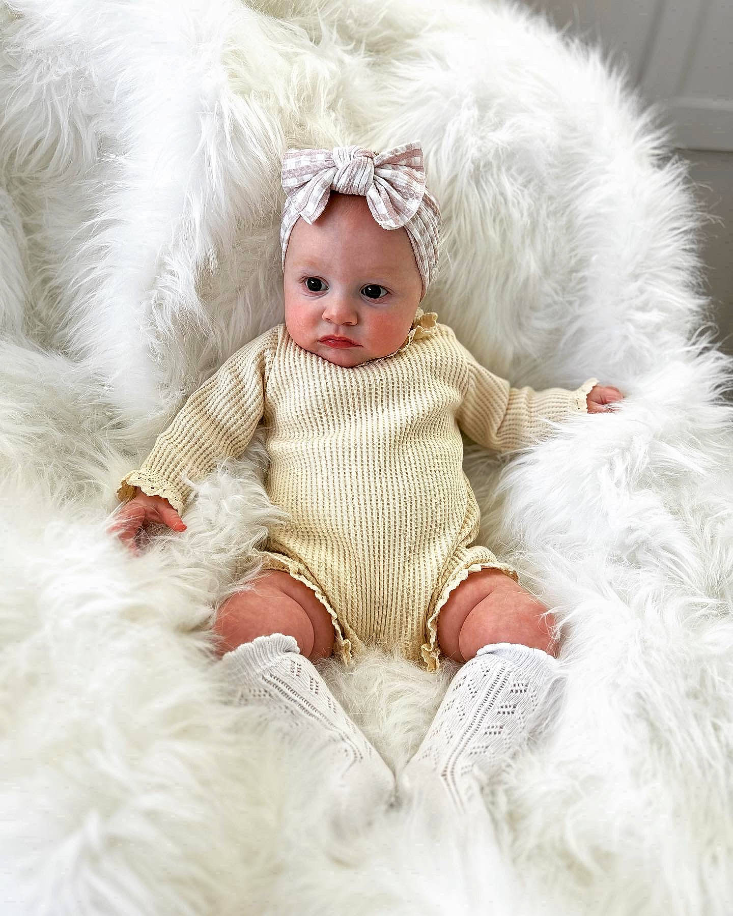 Indie is registered to the contest to win money with this photo: baby, baby_toddler_clothing, comfort, costume_accessory, costume_hat, dress, embellishment, eye, fashion_accessory, fur, hair_accessory, happy, headband, headpiece, iris, peach, person, portrait_photography, sitting, sleeve