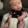 Carter is registered to the contest to win money with this photo: baby, infant, child, onesie, black_clothing, seat, baby_seat, face, blue_eyes, barefoot, hand, foot, expression, curious, indoors, couch, soft_light, portrait, skin, person