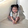 toddler, child, smiling, happy, hair_buns, sitting, floor, corner, wall, shadow, toy, playful, indoor, clothing, short_sleeves, baby, cute, person, portrait, infant
