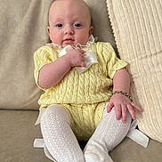 Bonnie May joined the competition — help win amazing prizes! baby, beige, bow, bracelet, child, closeup, comfort, couch, cute, face, footwear, hand, indoors, infant, knitwear, portrait, sitting, soft_furniture, white_socks, yellow_clothing