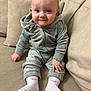 Bonnie May is registered to the contest to win money with this photo: baby, child, clothing, couch, cute, face, furniture, green, hair, hand, indoors, infant, person, pink, portrait, seated, smile, socks, sofa, tracksuit