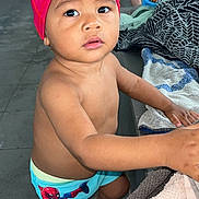 Djayden participe au concours pour gagner de l'argent avec cette photo : barefoot, child, curious, floor, headwear, indoor, looking_up, person, playful, pool_area, shorts, skin, spiderman, standing, swim_cap, swim_trunks, toddler, towel, wet_floor, young_child