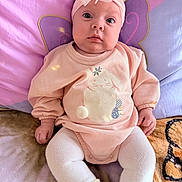 Aylani joined the competition — help win amazing prizes! baby, infant, headband, bow, pink_clothing, sweater, bunny_design, pom_pom, blanket, cushion, purple_background, seated, cute, wide_eyes, soft_lighting, indoors, child, toddler, sock, portrait