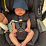 baby, infant, sleeping, car_seat, hat, blue_hat, black_car_seat, toy, stuffed_animal, safety_harness, child, cute, peaceful, hands, feet, indoors, portrait, seat_belt, comfort, resting