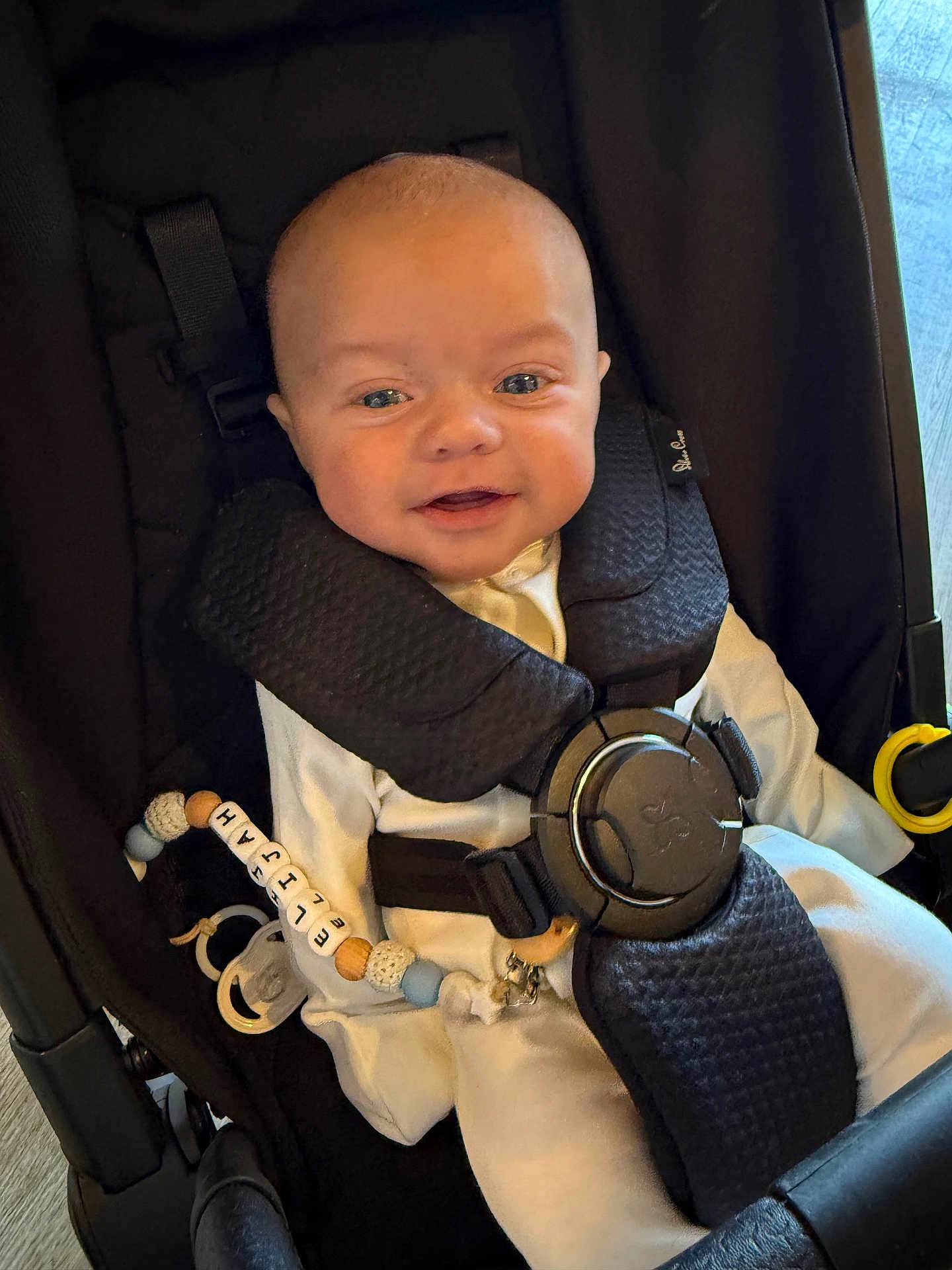Elijah joined the competition — help win amazing prizes! baby, smiling, stroller, infant, child, pacifier, clip, white_outfit, straps, seated, happy, indoors, person, closeup, cute, face, head, seatbelt, comfort, young