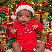 Michael is registered to the contest to win money with this photo: baby, infant, christmas, holiday, presents, gift_boxes, santa_hat, red_clothing, festive, decorations, christmas_tree, lights, cute, smiling, celebration, indoors, happy, seasonal, child, portrait