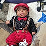 baby, bow_tie, child, closeup, comfortable, cozy, cushions, cute, fashion, indoor, infant, person, polka_dot_shirt, portrait, quilt, red_cap, red_pants, smiling, sneakers, suspenders