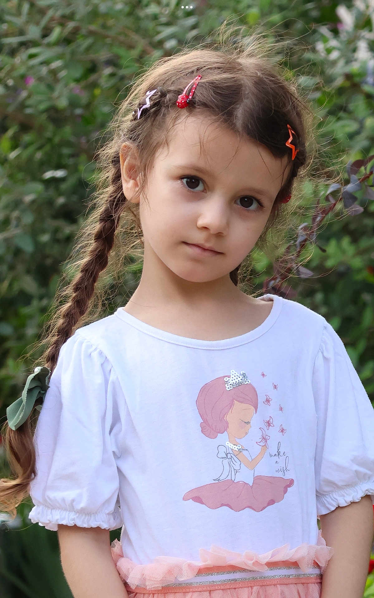 Aylin joined the competition — help win amazing prizes! child, girl, braids, hair_clips, white_shirt, princess_illustration, make_a_wish, pink_skirt, ruffles, outdoor, greenery, garden, portrait, cute, young, innocent, soft_expression, casual_clothing, summer, nature