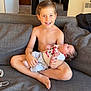 Lorenzo participe au concours pour gagner de l'argent avec cette photo : child, baby, boy, newborn, couch, pillow, shirtless, smiling, indoors, home, person, sitting, holding, cute, infant, clothing, happy, family, living_room, relaxing