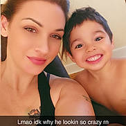 Noah is registered to the contest to win money with this photo: woman, child, smiling, selfie, face, portrait, tattoo, indoors, casual, happy, black_tank_top, short_hair, brown_hair, light_skin, cheerful, playful, caption_overlay, text_overlay, sunday, young_boy