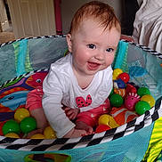 Freya joined the competition — help win amazing prizes! baby, child, playpen, toys, balls, smiling, happy, indoors, colorful, clothing, sitting, face, person, cute, infant, playtime, mesh, home, cheerful, young