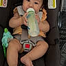 Eliana is registered to the contest to win money with this photo: baby, car_seat, bottle, child, infant, plush_toy, seatbelt, straps, clothing, cute, sitting, indoor, person, face, foot, hand, expression, safety, child_seat, baby_bottle
