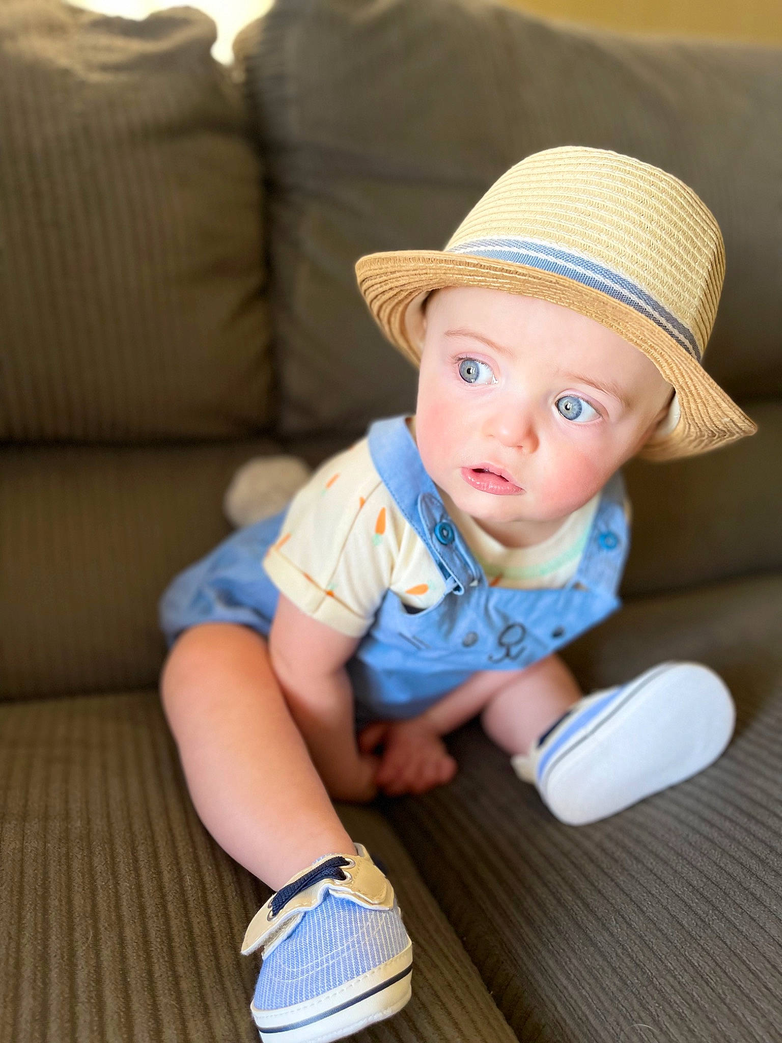 Calum is registered to the contest to win money with this photo: baby, baby_toddler_clothing, cap, child, electric_blue, fedora, finger, flooring, happy, hat, headwear, human_leg, person, shoe, sitting, skin, sneakers, sun_hat, toddler, white