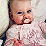 baby, pacifier, pink_onesie, child, infant, blue_eyes, blanket, pillow, cute, portrait, indoor, soft_lighting, hand, clothing, face, person, newborn, closeup, sleepwear, baby_girl