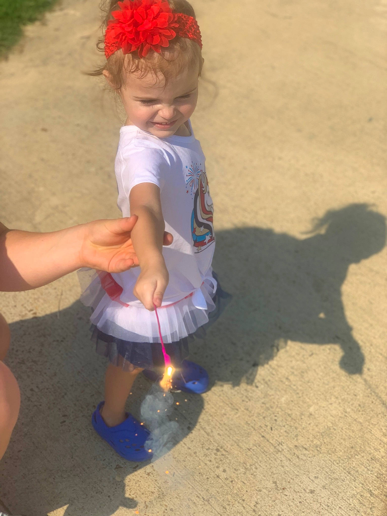 Ainsley is registered to the contest to win money with this photo: barefoot, child, event, flip_flops, foot, fun, grass, happy, human_leg, knee, leisure, people_in_nature, person, recreation, sand, sandal, shadow, shorts, sitting, slipper