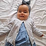 Juliette participe au concours pour gagner de l'argent avec cette photo : baby, child, infant, headband, bow, cardigan, dress, blue_dress, grey_cardigan, white_sheet, lying_down, smiling, cute, adorable, portrait, face, happy, indoor, person, young_child