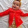 Juliette participe au concours pour gagner de l'argent avec cette photo : baby, bow, bright_colors, child, clothing, cute, face, floral_pants, happy, headband, headwear, indoors, infant, lying_down, orange_jacket, person, portrait, smiling, white_blanket, young_child