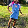 Robyn joined the competition — help win amazing prizes! child, girl, outdoor, grass, sunlight, denim_dress, braids, pink_beads, smile, shoes, casual_clothing, playful, happy, nature, yard, tree, sunny_day, portrait, standing, fashion