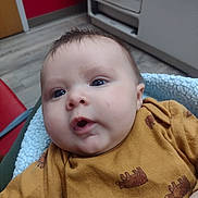 Branston is registered to the contest to win money with this photo: baby, blanket, bodypart, clothing, couch, cushion, face, finger, frown, furniture, hand, head, homedecor, knitwear, mouth, newborn, person, photography, portrait, sad