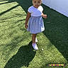 Heaven joined the competition — help win amazing prizes! child, girl, dress, grass, shadow, outdoor, sunlight, fence, white, smile, standing, person, young, casual_clothing, footwear, happy, daylight, playground, cute, portrait