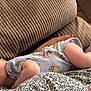 baby, cartoon_print, casual, closeup, comfort, cushion, fabric, feet, hand, indoor, infant, nail_polish, onesie, pattern, person, relaxation, rest, skin, sleeping, texture
