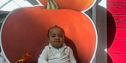 Alani is registered to the contest to win money with this photo: autumn_leaves, baby, bench, booties, child, cute, decoration, fall, holiday, indoor, nike, person, portrait, pumpkin, red_wood, shadow, sitting, smiling, sunlight, white_outfit