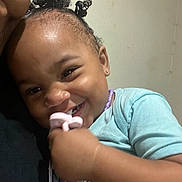 Alani joined the competition — help win amazing prizes! toddler, child, smiling, curly_hair, pacifier, earrings, blue_shirt, close_up, indoor, person, happy, cute, portrait, holding, jewelry, playful, baby, infant, human, face