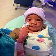 Alani joined the competition — help win amazing prizes! baby, bed, blanket, child, cute, eyes, face, hand, hat, healthcare, hospital, indoors, infant, medical_tubes, newborn, patient, person, swaddled, tattoo, wrapped
