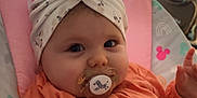 Abbygaël participe au concours pour gagner de l'argent avec cette photo : baby, infant, pacifier, head_wrap, orange_clothing, baby_seat, cushion, indoor, child, face, cute, comfort, soft, patterned_fabric, pink, gray, zebra, calm, portrait, closeup