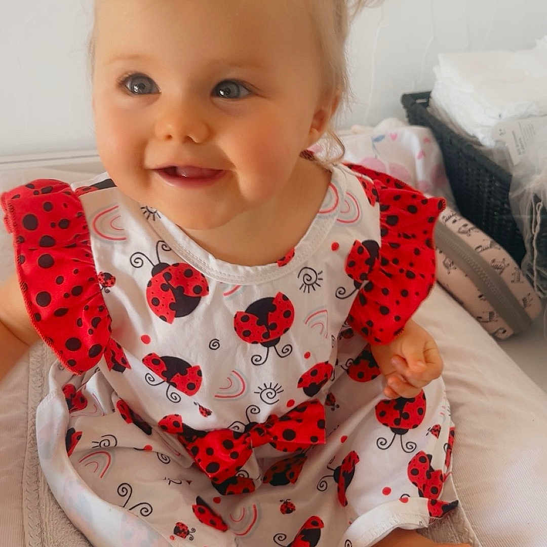 Abbygaël a rejoint le concours — aidez-le/la à gagner de superbes lots ! baby, basket, cheerful, child, clothing, cute, diapers, dress, foot, happy, indoor, infant, ladybug_pattern, person, pigtails, portrait, sitting, smiling, soft, towel