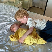 Sonny joined the competition — help win amazing prizes! baby, toddler, bed, blanket, child, curly_hair, indoor, laying_down, light, mirror, nightstand, pajamas, person, quiet, room, soft_lighting, white, yellow_clothing, family, affection