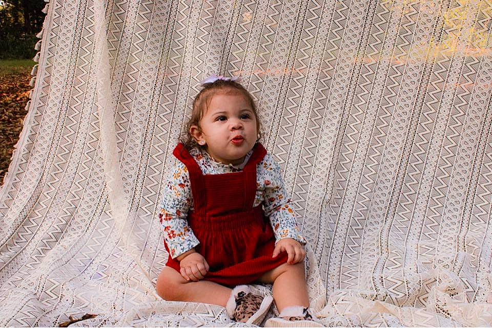 Naomi joined the competition — help win amazing prizes! baby, baby_toddler_clothing, child, dress, fashion_design, flash_photography, flooring, fun, grass, hairstyle, happy, linens, magenta, pattern, people_in_nature, person, plant, sitting, skin, toddler