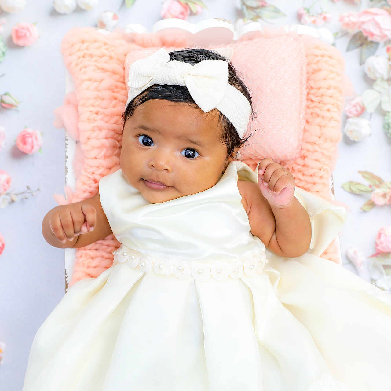 Miela is registered to the contest to win money with this photo: baby, child, infant, portrait, lying_down, smiling, dress, bow, headband, floral_background, roses, flowers, pink, white, blanket, studio_photography, fashion, adorable, face, indoor