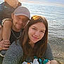 Everett is registered to the contest to win money with this photo: baby, blanket, cap, child, family, happy, holding, man, nature, outdoor, pacifier, people, portrait, sea, selfie, smile, sunset, toddler, water, woman