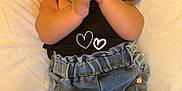 Daleyza is registered to the contest to win money with this photo: baby, infant, smiling, clothing, denim_shorts, black_top, cushion, white_background, happy, hands, hair_clip, skin, cute, lying_down, person, child, indoors, portrait, baby_girl, soft_texture