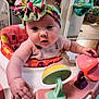 baby, child, headband, toy, walker, indoor, person, infant, colorful, play, furniture, curious, chubby, hand, face, expression, room, clothing, seat, background