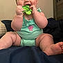 baby, child, infant, teether, green_teether, mint_onesie, shell_emblem, sitting, smiling, happy, indoor, blanket, navy_blanket, cute, chubby_arms, chubby_legs, person, face, head, teeth
