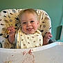 Oliver is registered to the contest to win money with this photo: baby, high_chair, bib, messy, food, smiling, tongue, bread, happy, face, child, feeding, meal, clothing, person, indoor, expression, cute, seat, table