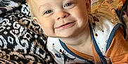 Oliver joined the competition — help win amazing prizes! baby, infant, smiling, face, blue_eyes, blond_hair, blanket, patterned, clothing, onesie, cute, lying_down, hands, happy, indoors, portrait, child, soft_lighting, cozy, expression